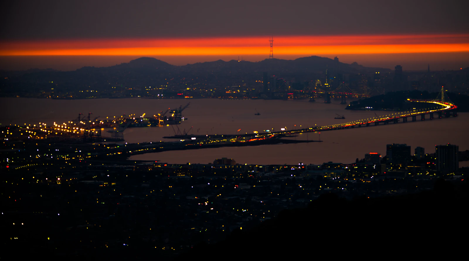 Aerial photograph of a bridge and the surrounding city at dusk